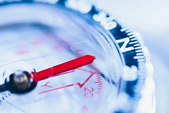 close up image of a compass with the needle pointing north