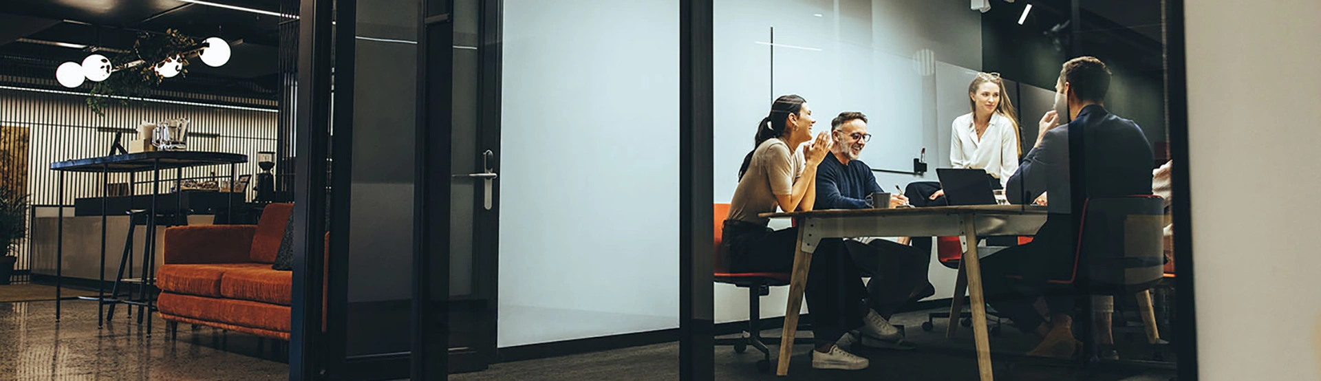 Four colleagues in a glass conference room discussing corporate bonds and structured finance