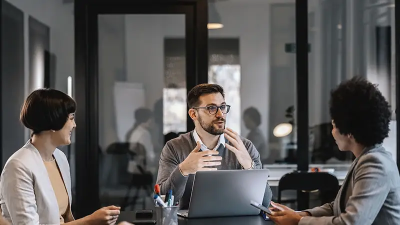 Three professionals discussing ABS market