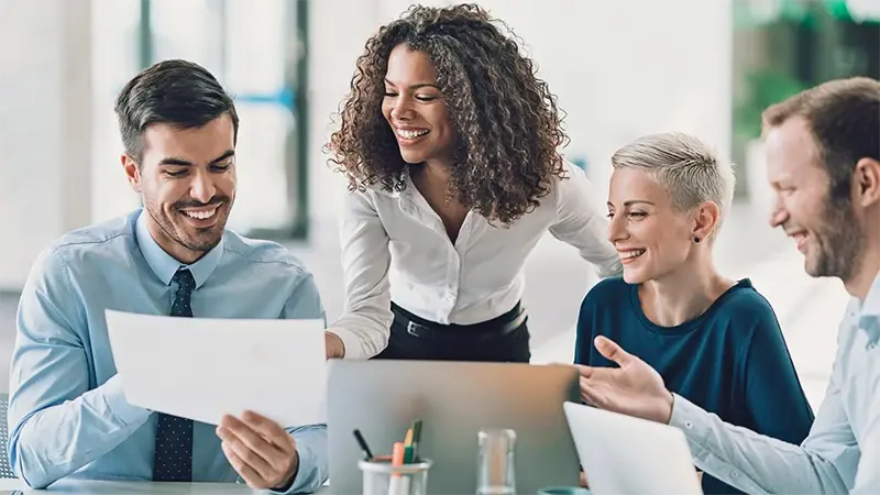 Four professionals smiling and talking about fund operations in Luxembourg