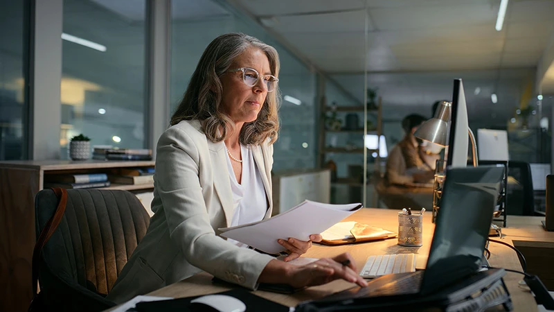 Woman in her office in the evening researching investment funds in Luxembourg
