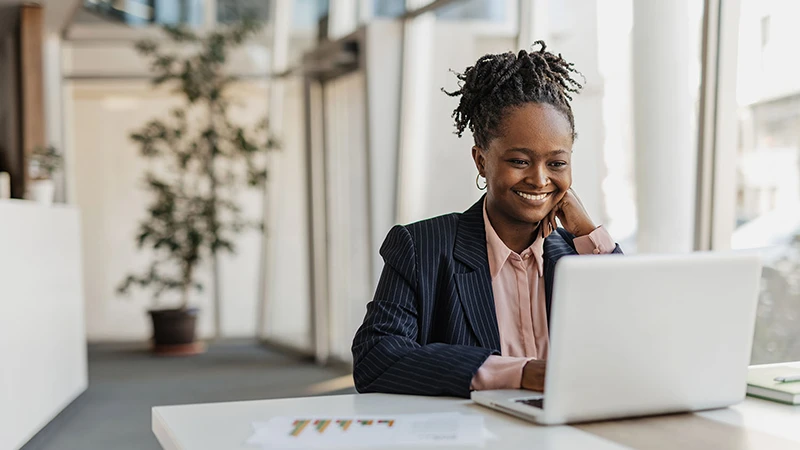 Professionally dressed woman at her laptop researching trust Luxembourg 