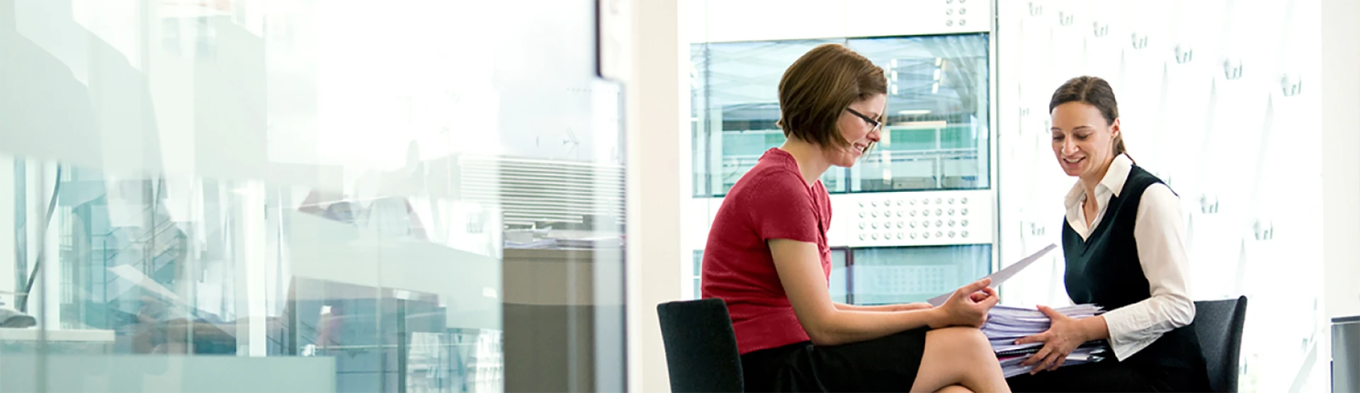 Two professional women facing each other discussing funds administrative services